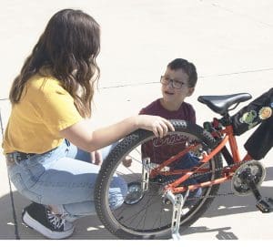 Ford Hall speaks with Adrianna Gutierrez as he inspects his new bike.