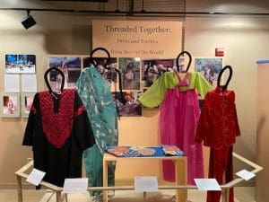 This photos shows part of an exhibit entitled "Journey Around the World" created by the 2019 Spring Exhibition Class. It shows traditional clothing from Asia.