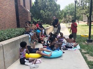 A Wichita State police officer visits with local children before their swim lessons.