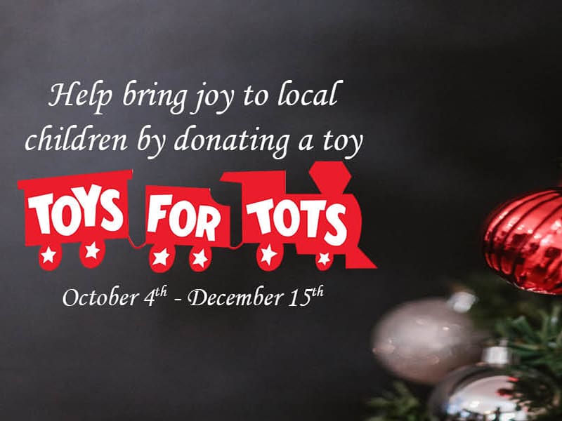 A Christmas tree background with the words "Help bring joy to local children by donating a toy Toys-for-Tots October 4th-December 15th"