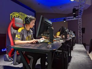 Wichita State University's Truman Nguyen is sitting at a computer in The Hub room representing the Esports team for the videogame, Valorant