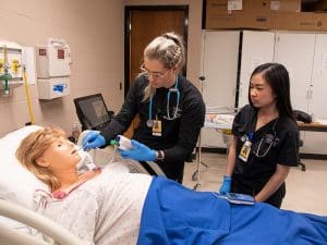 WSU nursing students work on a simulation manikin