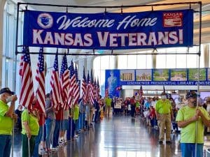 Image of veterans holding large flags at lobby of Eisenhower Airport.