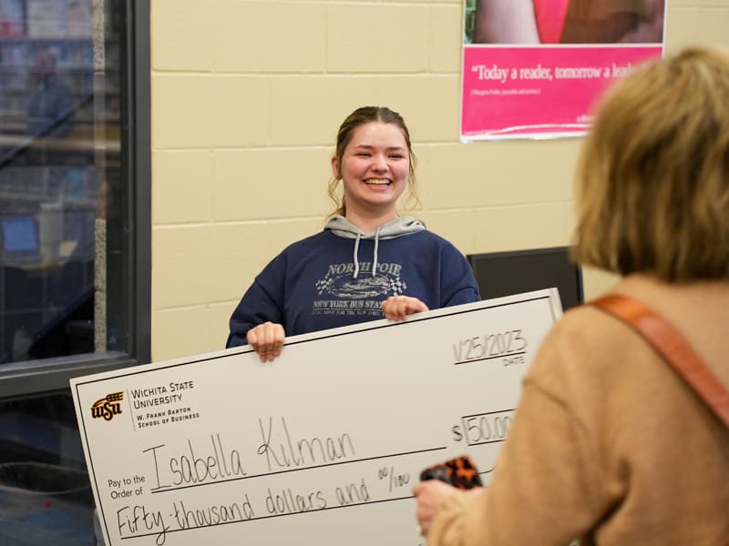 Photo of Isabella (Bella) Kilman holding the $50,000 scholarship check.