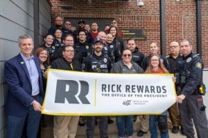 A photo of the WSUPD with President Rick Muma holding up the Rick Rewards sign.