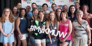 A photo of a group of KMUW volunteers holding a "#MyKMUW" sign..