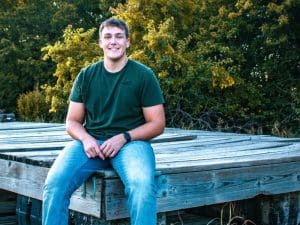 Photo of Kyan Caudillo sitting on a wooden dock.