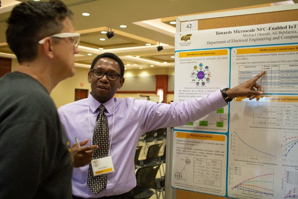 Photo of a student presenting his research poster in the GRASP Symposium at Wichita State.