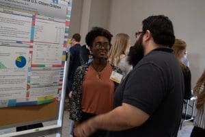 Photo of two students talking about a research poster in GRASP.