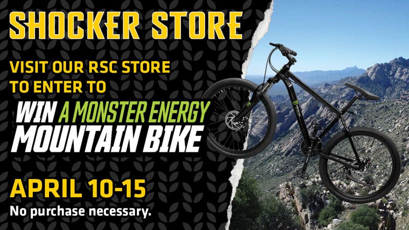 Graphic with a photo of the mountain bike being given away set against a backdrop of a sprawling mountain and the text, "Shocker Store. Visit our RSC store to enter to win a Monster Energy mountain bike. April 10-15. No purchase necessary."