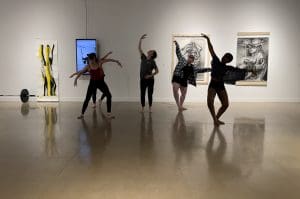 Photo of dancers from the WSU Dance Program performing in front of artwork in the Polk/Wilson Gallery.