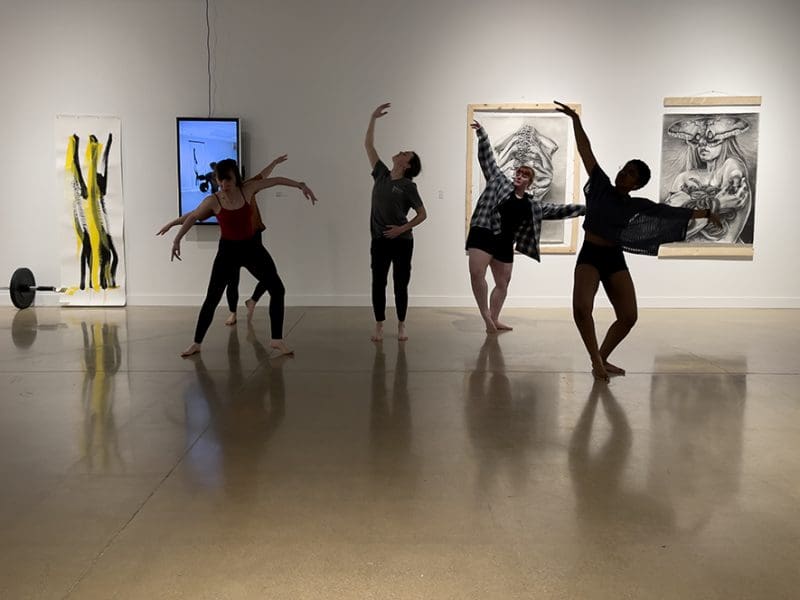 Photo of dancers from the WSU Dance Program performing in front of artwork in the Polk/Wilson Gallery.