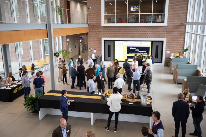 Wide shot photo of attendees interacting with each other at the Innovation Campus mixer.