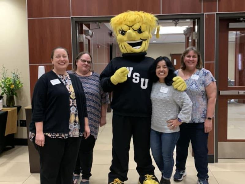 Photo of four faculty members pose with WuShock.