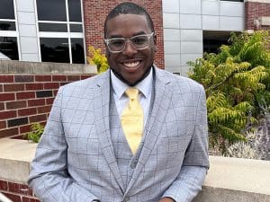 Gregory VanDyke Jr. in front of a building