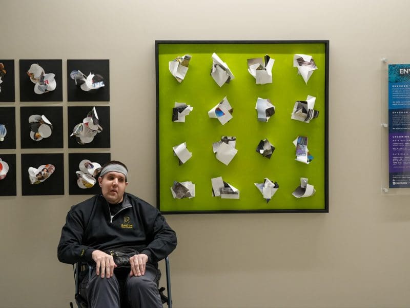 Photo of Nick Wooding in front of the Envision art installation in Woolsey Hall.