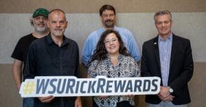 Photo of the Performance Facilities team with President Rick Muma holding a sign that says "#WSURickRewards."