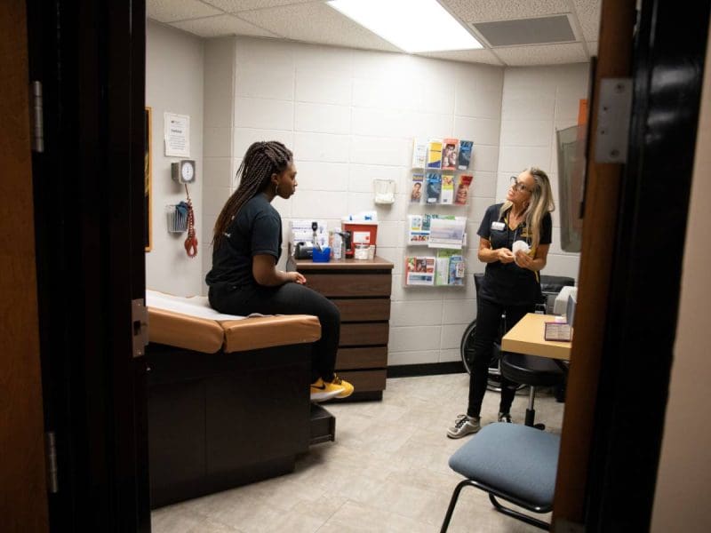 Photo of a student being seen by a campus health professional.