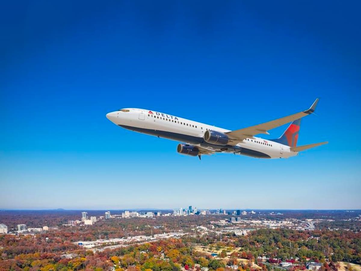 A Delta Airlines plane flying over a city.