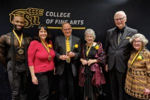 The inductees with Rodney Miller in front of a Wichita State University backdrop.