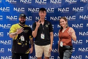 Joe Mazzara, Assistant Director of Esports; Travis Yang, Director of Esports; and Avery Pierce, Assistant Director of Programming; posing in front of the NACE backdrop