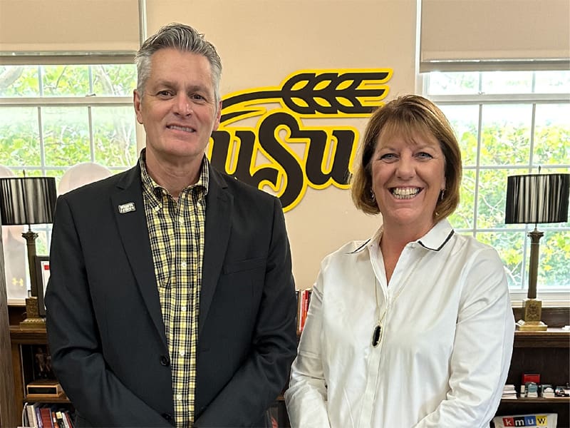 President Rick Muma and Provost Shirley Lefever stand in front of a WSU sign