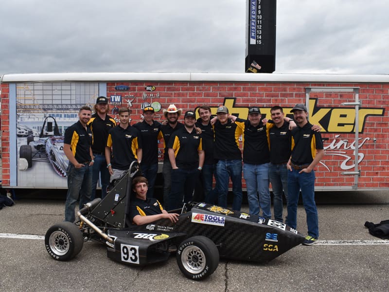 The Shocker Racing team take a group photo with the formula car
