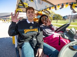 Students riding a cart at Shocktoberfest