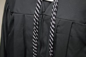 Black and White colored adult learning graduation cord with black graduation robe