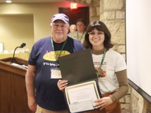 Shania Burkhead-Harris holds her certificate and award check with Dr. Tom Luhring