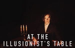 "At the Illusionist's Table" Photo shows a young man in candlelight at a table