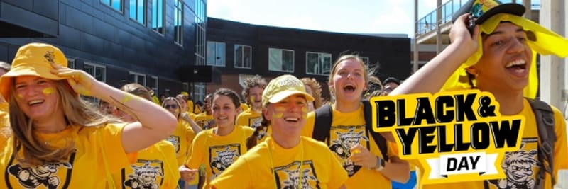 Students celebrating on campus with the text Black & Yellow Day