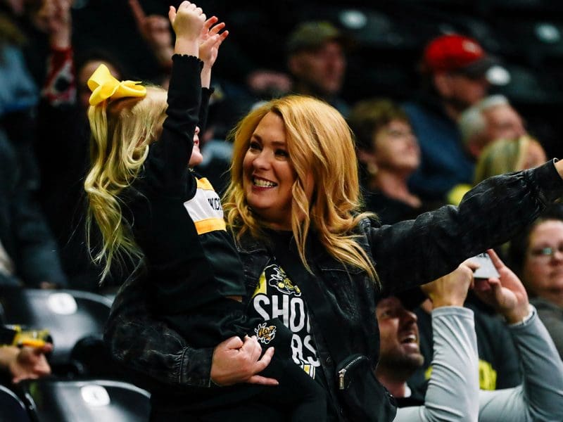 Shocker fans holds young child while cheering at a recent game