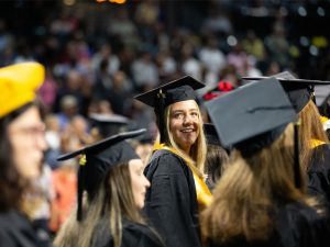 Students in their regalia attend fall 2023 commencement.