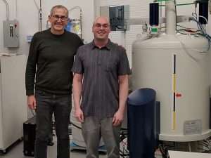 Prof. Jim Bann) and Dr. Dustin Nevonen standing next to the newly installed 500 MHz Bruker AVANCE NEO nuclear magnetic resonance instrument.