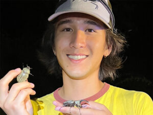 Max Proctor, one of the students awarded, holds a Hercules beetles