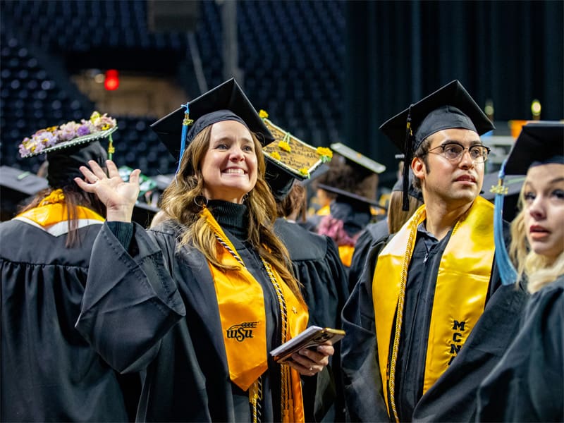 Students wear their graduation regalia at commencement