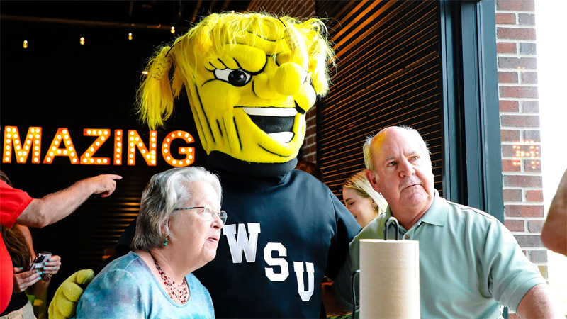 WuShock poses with Shocker fans for photo at Shocker Caravan event in Overland Park