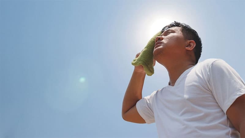 A man towels off under the summer heat