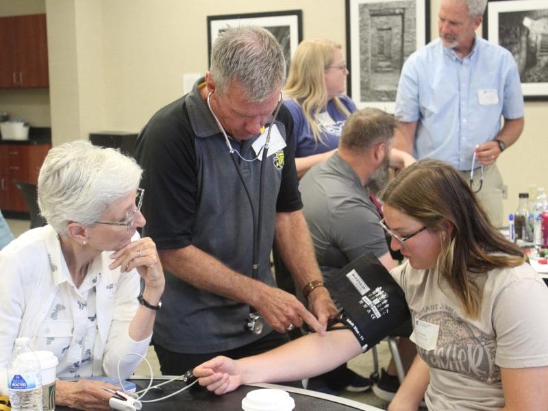 Attendee of the High School Teacher's Workshop tests vital signs on a fellow participant