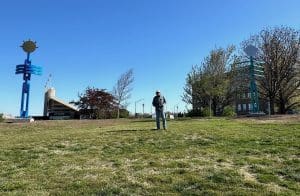 Artist Doug Coffin stands between two of his sculptures on the WSU campus.