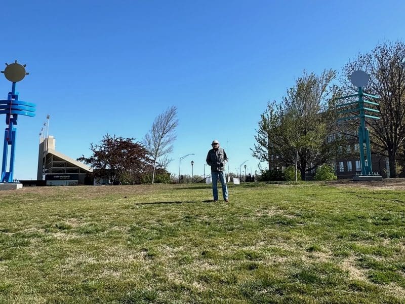 Artist Doug Coffin stands between two of his sculptures on the WSU campus.