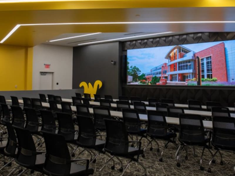 A classroom in the Milly Marcus Annex with chairs facing a large projector