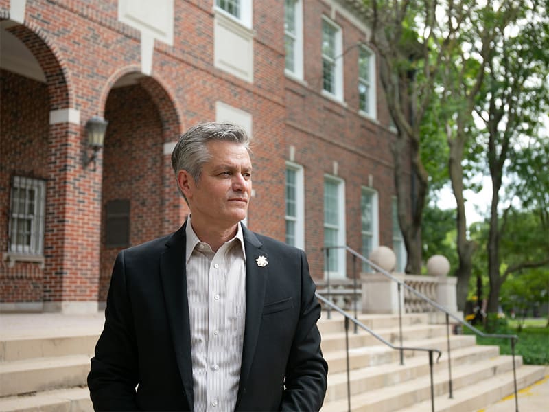 President Rick Muma stands in front of Morrison Hall