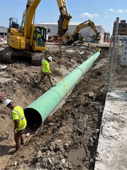 Construction workers place sewer and electrical down at the Wichita Biomedical Campus site.