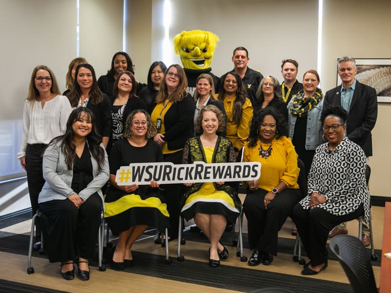 President Rick Muma and WuShock poses with the Office of Financial Aid for Rick Rewards