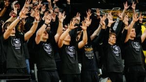 A large group of students cheers on the basketball team in the student section during a men's basketball game