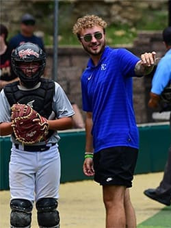 Ryan Summerlin on baseball field with player giving directions.