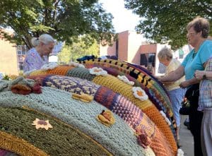 Artists put knitted sections on Tom Ottterness' "Millie" sculpture.