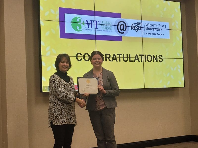 First Place winner Mary Peterson receiving a certificate from Graduate school Dean Coleen Pugh.